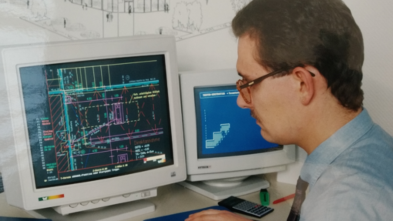 Mann an einem Computer-Arbeitsplatz mit alten Röhren-Monitoren